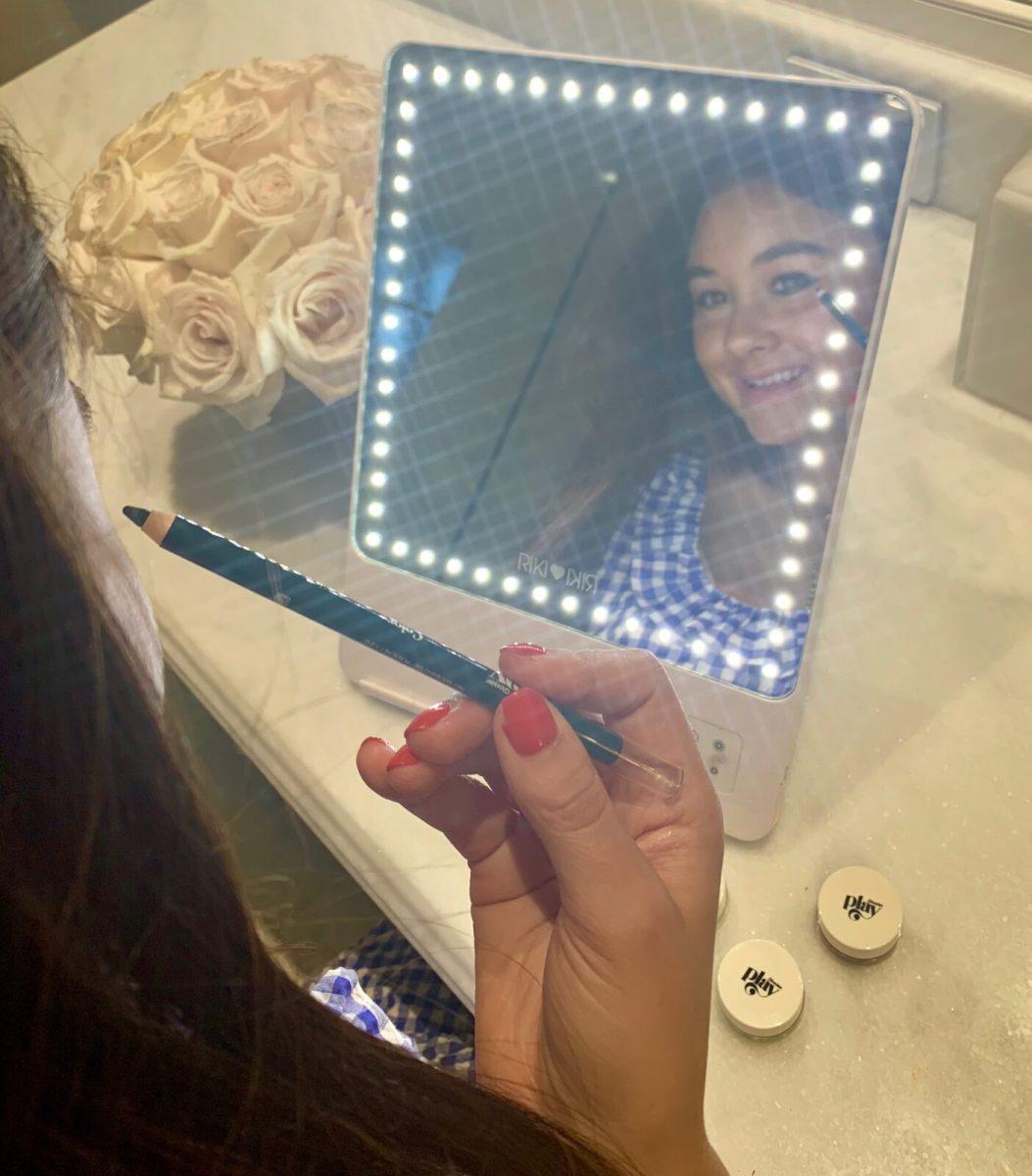 Sophie McGuire applying Glossier Play