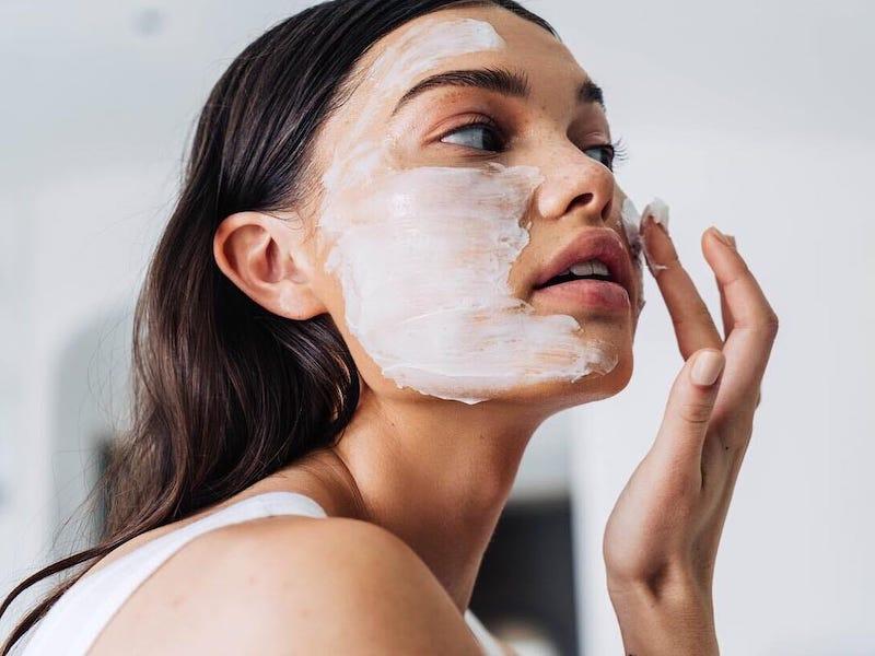 woman applying a face mask Photo credit: business insider